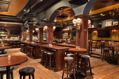 a bar with wooden tables and bar stools at Days Inn by Wyndham Vancouver Downtown in Vancouver