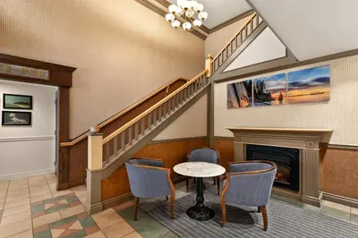 a living room with a staircase and a table and chairs at Days Inn by Wyndham Vancouver Downtown in Vancouver
