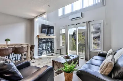 a living room with leather furniture and a fireplace at CHARMING 1 Bdrm plus loft with VIEWS managed by Little Sister Getaways in Canmore