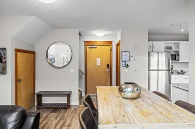 a kitchen and dining room with a wooden table and chairs at CHARMING 1 Bdrm plus loft with VIEWS managed by Little Sister Getaways in Canmore