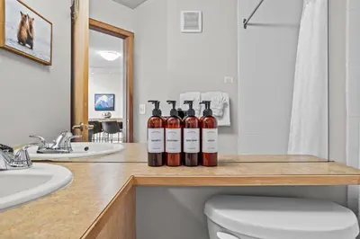 four bottles of wine sitting on a counter in a bathroom at CHARMING 1 Bdrm plus loft with VIEWS managed by Little Sister Getaways in Canmore