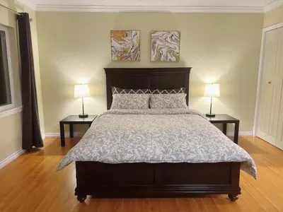 a bedroom with a large bed with two lamps on both sides at Private Suite with Separated Entrance Monica's Home in Richmond