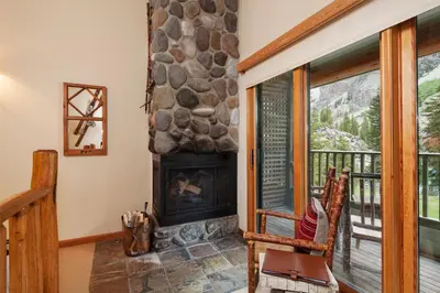 a stone fireplace in a living room with a window at Moraine Lake Lodge in Lake Louise