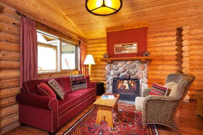 a living room with a couch and a fireplace at Cathedral Mountain Lodge in Field