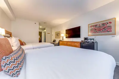 a hotel room with two beds and a television at Listel Whistler, a Coast Hotel in Whistler
