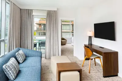 a living room with a blue couch and a desk at Hilton Vancouver Downtown, BC, Canada in Vancouver