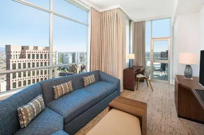 a living room with a blue couch and a large window at Hilton Vancouver Downtown, BC, Canada in Vancouver