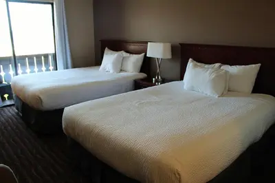 two beds in a hotel room with a window at Ramada by Wyndham Campbell River in Campbell River