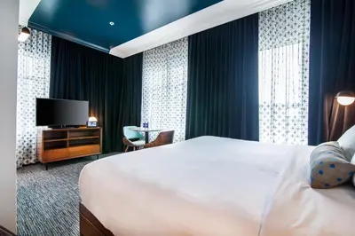 a hotel room with a bed and a television at Hotel Belmont Vancouver - MGallery Collection in Vancouver