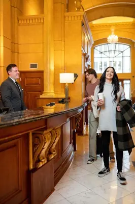 a woman standing next to a counter in a lobby at Hotel Le Soleil by Executive Hotels in Vancouver