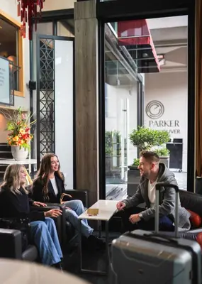 a group of people sitting around a table in a restaurant at The Parker Hotel and Rooftop in Vancouver