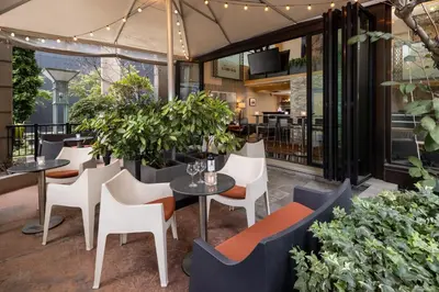 a restaurant with tables and chairs and plants at The Parker Hotel and Rooftop in Vancouver