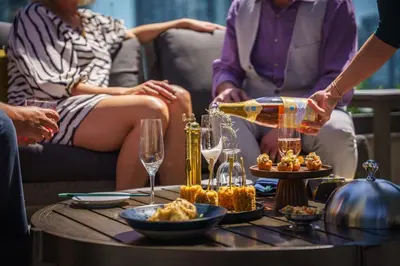 a group of people sitting around a table drinking wine at The Parker Hotel and Rooftop in Vancouver