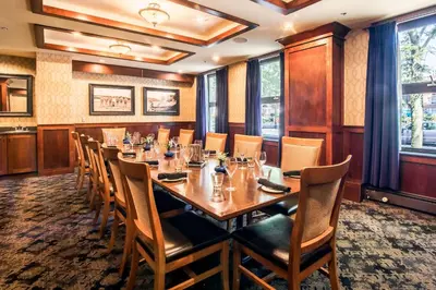 a dining room with a long table and chairs at The Sylvia Hotel in Vancouver