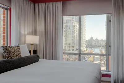 a bedroom with a large bed and a large window at OPUS Vancouver in Vancouver