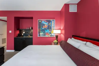 a bedroom with a red wall with a bed at OPUS Vancouver in Vancouver