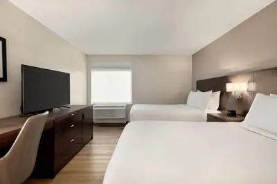 a hotel room with two beds and a flat screen tv at La Quinta Inn by Wyndham Vancouver Airport in Richmond