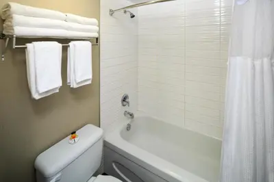 a bathroom with a white tub and a toilet and a shower at Accent Inns Vancouver Airport in Richmond