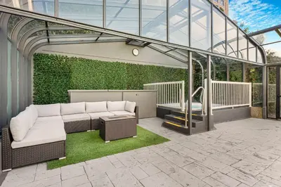 a glassconservatory with a couch and a table at Days Inn by Wyndham Victoria On The Harbour in Victoria