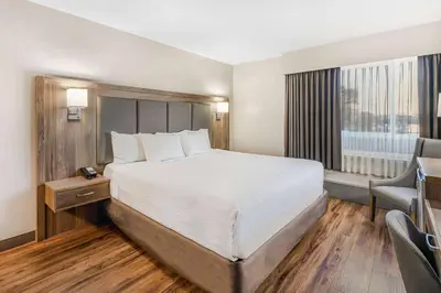 a hotel room with a large bed and a window at Days Inn by Wyndham Victoria On The Harbour in Victoria