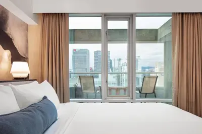 a hotel room with a bed and a large window at Delta Hotels by Marriott Vancouver Downtown Suites in Vancouver