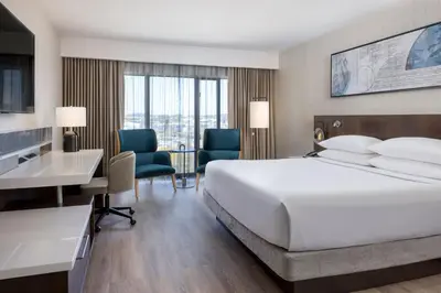 a hotel room with a bed and a desk and chairs at Delta Hotels by Marriott Victoria Ocean Pointe Resort in Victoria
