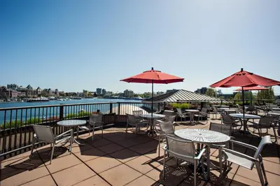 a patio with tables and chairs and umbrellas at Delta Hotels by Marriott Victoria Ocean Pointe Resort in Victoria