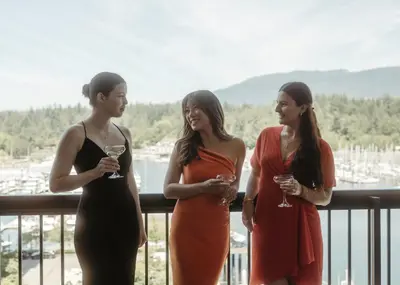 three women standing on a balcony with glasses of wine at The Westin Bayshore, Vancouver in Vancouver