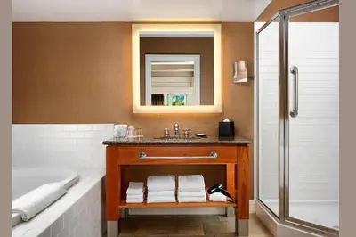 a bathroom with a sink and a tub and a mirror at The Westin Bear Mountain Resort & Spa, Victoria in Victoria