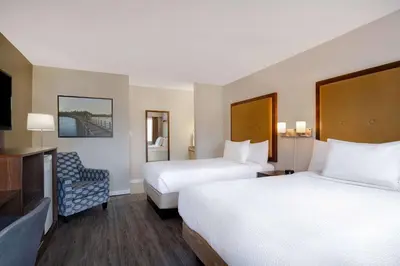 a hotel room with two beds and a tv at Days Inn by Wyndham Victoria Uptown in Victoria