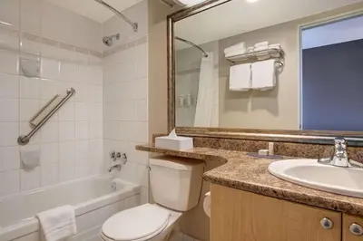 a bathroom with a toilet and a sink and a tub at Days Inn by Wyndham Victoria Uptown in Victoria