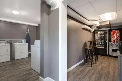 a kitchen with white appliances and a bar in a room at Days Inn by Wyndham Victoria Uptown in Victoria