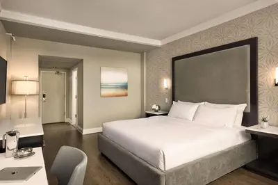 a bedroom with a large white bed and a desk at Georgian Court Hotel, WorldHotels Elite in Vancouver