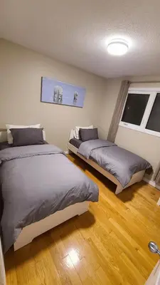 two beds in a room with wood floors at YK Aurora in Yellowknife