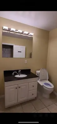 a bathroom with a sink and a toilet and a mirror at YK Aurora in Yellowknife