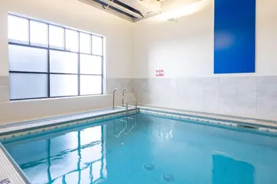 a swimming pool with blue water and a window at DoubleTree by Hilton Calgary North in Calgary