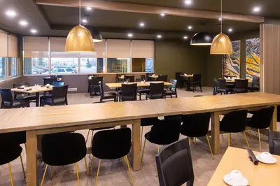 a restaurant with a large wooden table and chairs at DoubleTree by Hilton Calgary North in Calgary