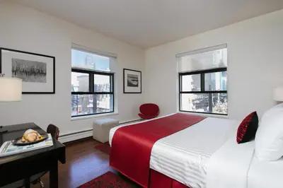 a bedroom with a bed and two windows at Moda Hotel in Vancouver