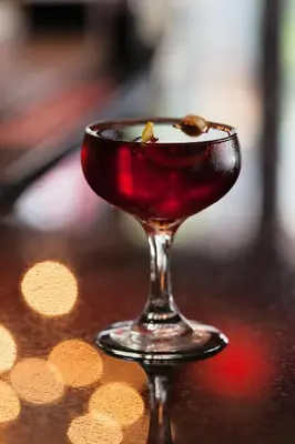 a drink in a wine glass sitting on a table at Moda Hotel in Vancouver