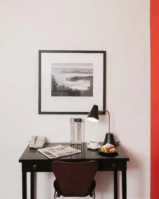 a desk with a chair and a lamp and a picture at Moda Hotel in Vancouver
