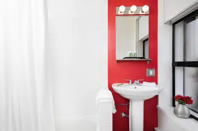 a red bathroom with a sink and a mirror at Moda Hotel in Vancouver