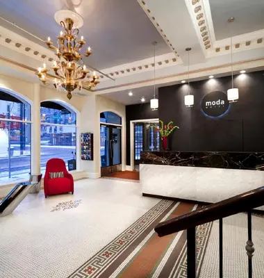 a lobby of a hotel with a red chair and a chandelier at Moda Hotel in Vancouver
