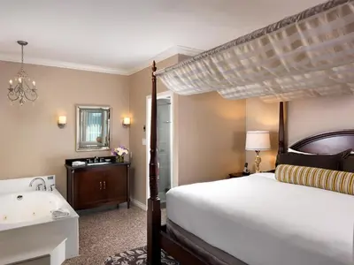 a bedroom with a bed and a tub and a sink at Hotel Grand Pacific in Victoria