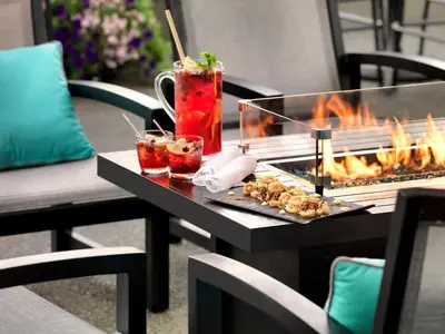 a table with two cocktails and a fire grill at Hotel Grand Pacific in Victoria