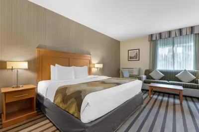 a hotel room with a bed and a couch at Best Western King George Inn & Suites in Surrey