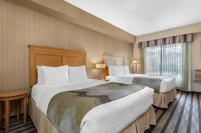 a hotel room with two beds and a window at Best Western King George Inn & Suites in Surrey