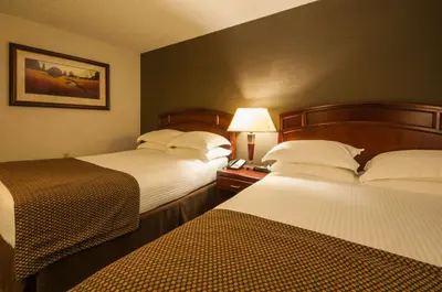 a hotel room with two beds and a lamp at Best Western Airport Inn in Calgary