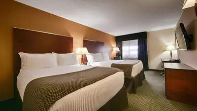a hotel room with two beds and a window at Best Western Airport Inn in Calgary