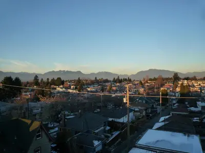 a view of a city with snow covered roofs at Cassandra Hotel in Vancouver