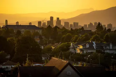 a city skyline at sunset with houses and buildings at Cassandra Hotel in Vancouver